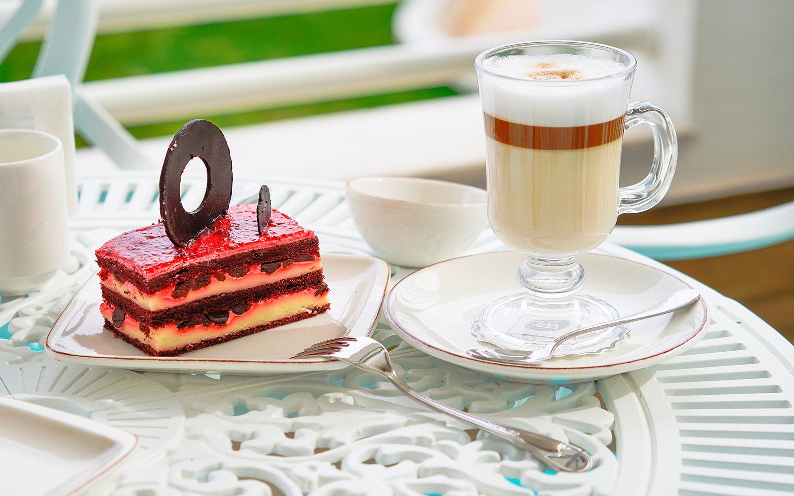 There is a piece of cake and a cup of coffee on the table.