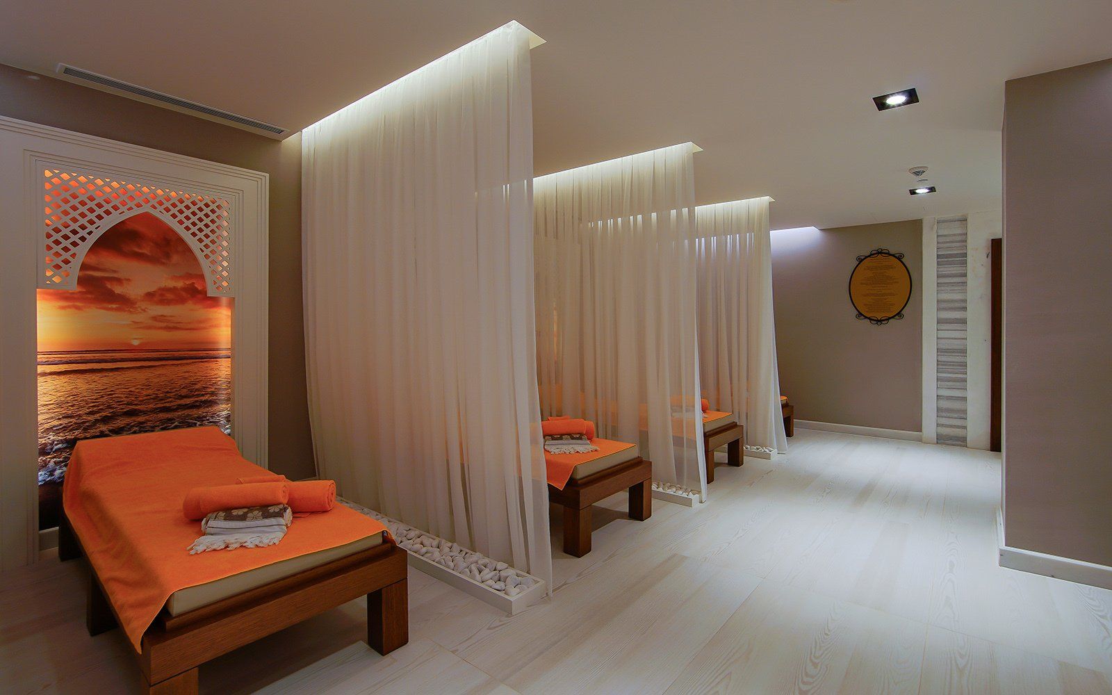 A room with a lot of beds and curtains in it.