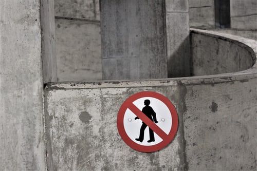 a no pedestrians sign is on a concrete wall