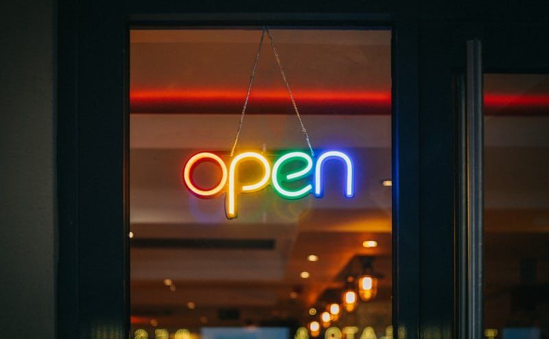a neon sign that says `` open '' is hanging in a window .