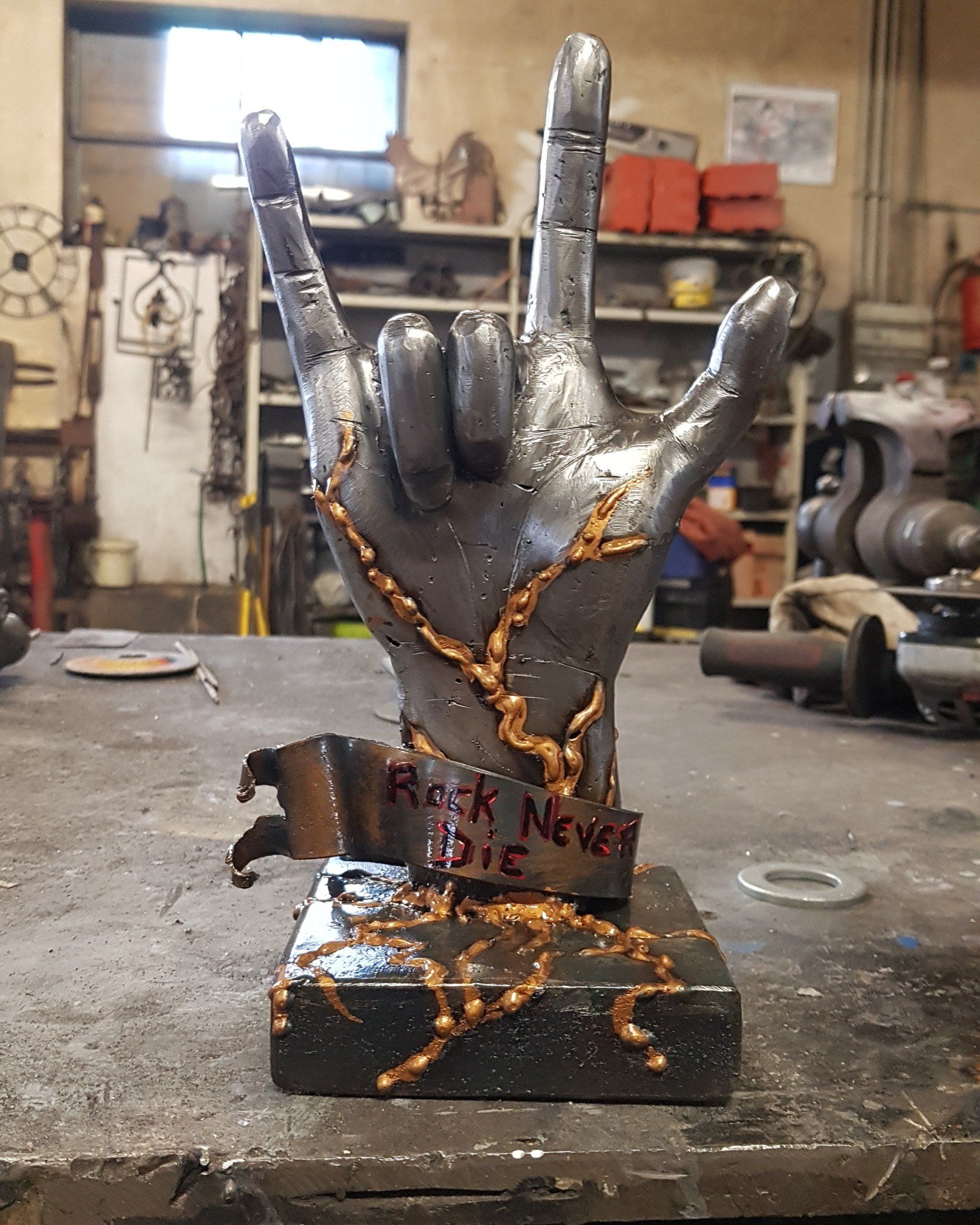 Scultura in metallo a forma di mano con la scritta