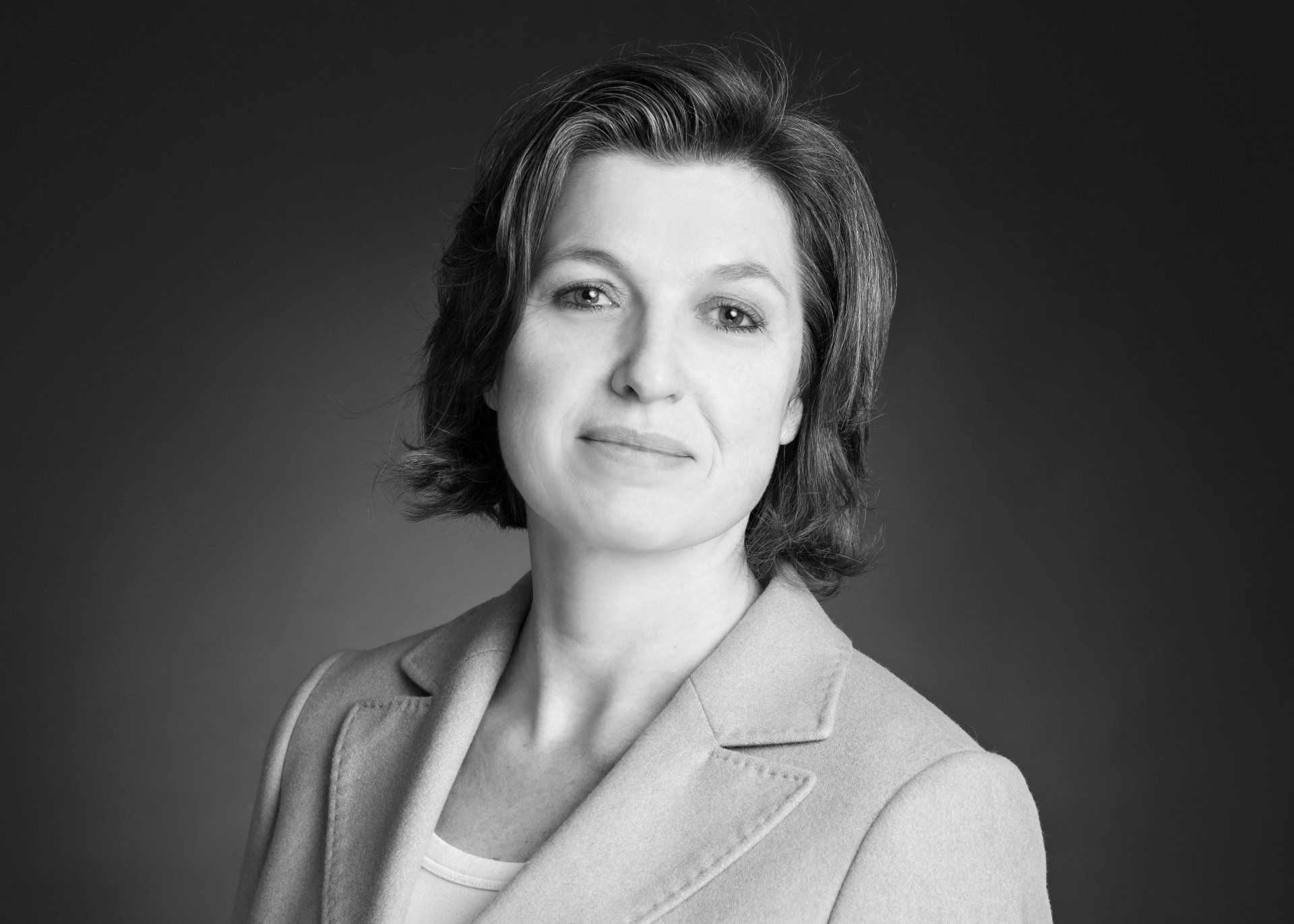 Ein Schwarzweißfoto einer Frau im Anzug.