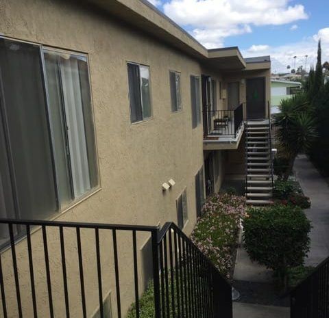 Exterior stairs leading from second story to walkway next to apartment building