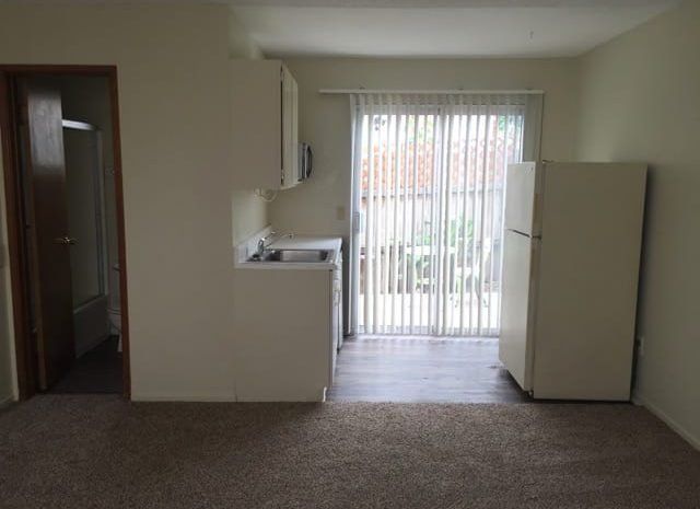 Kitchen next to carpeted dining area.