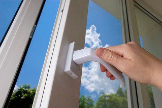 hand opening a door with uPVC lock