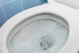 White toilet bowl with swirling water.