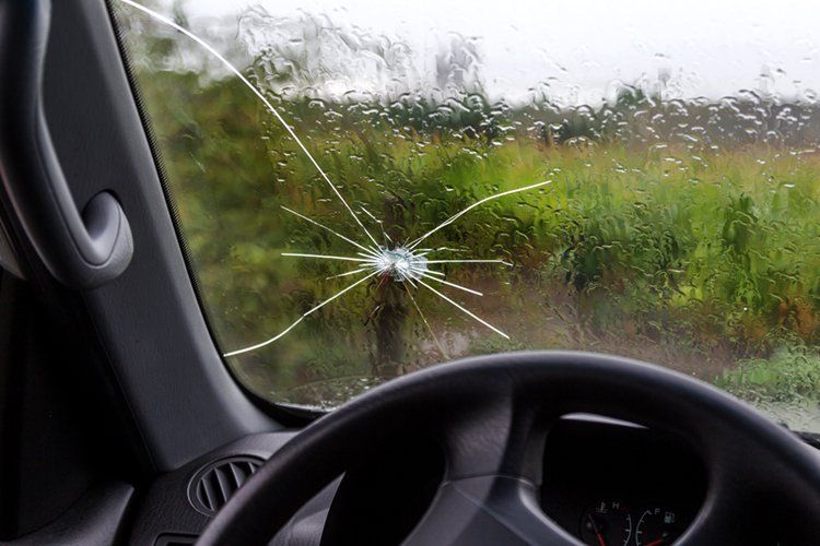 A car with a broken windshield and a steering wheel.