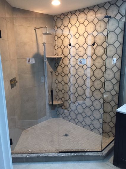 A bathroom with a walk in shower and a tiled wall.