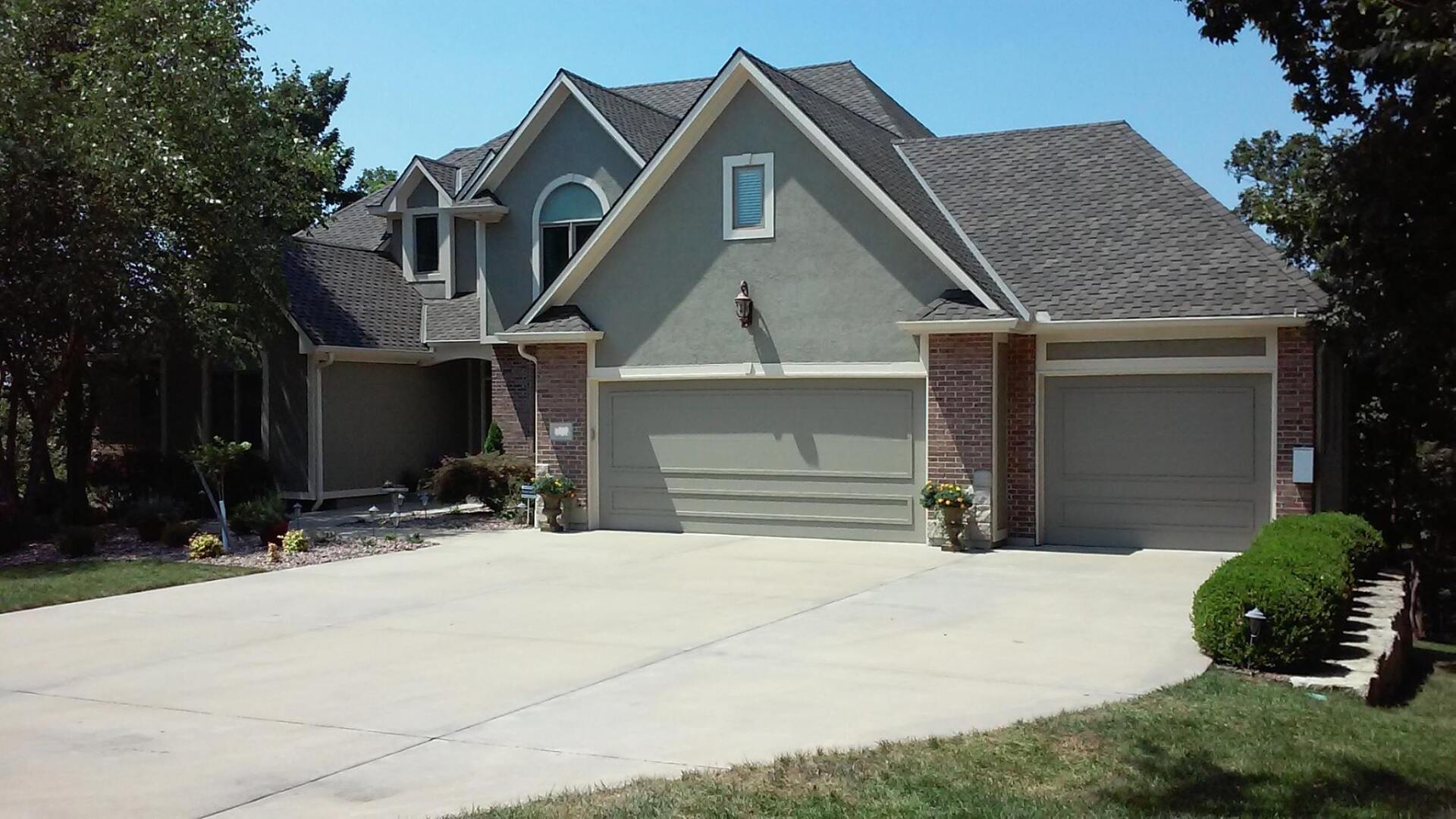 A large house with two garage doors and a driveway