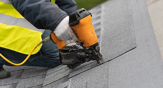 Worker using nail gun install roof shingles — Raymore, MO — Meissen & Sons Roofing Worker using nail gun install roof shingles — Raymore, MO — Meissen & Sons Roofing