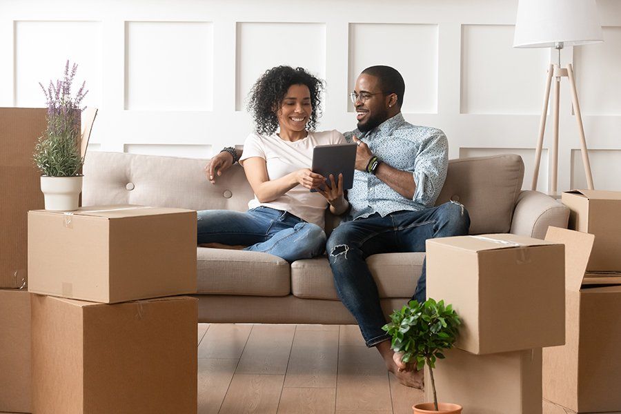 Couple Use Digital Tablet On Moving Day — Houston, TX — Los Flores Movers