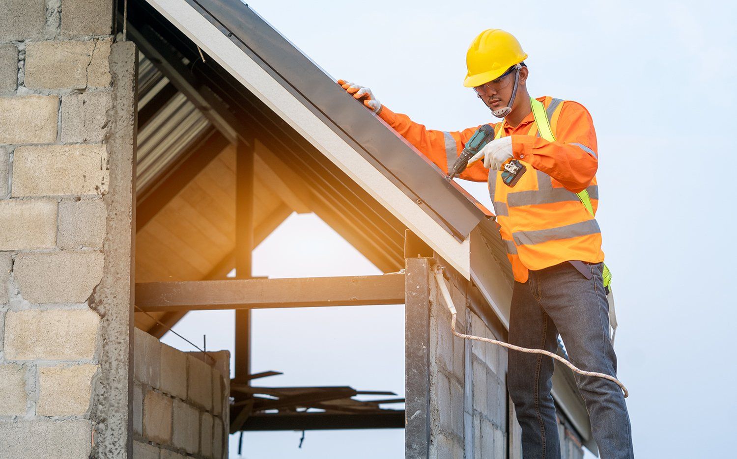 A picture of a guy drilling in a roof on a house in Asheville, NC.