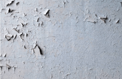 Cracked and peeling blue-gray paint on a wall.