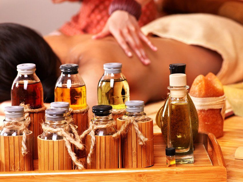 Young woman getting massage in bamboo spa