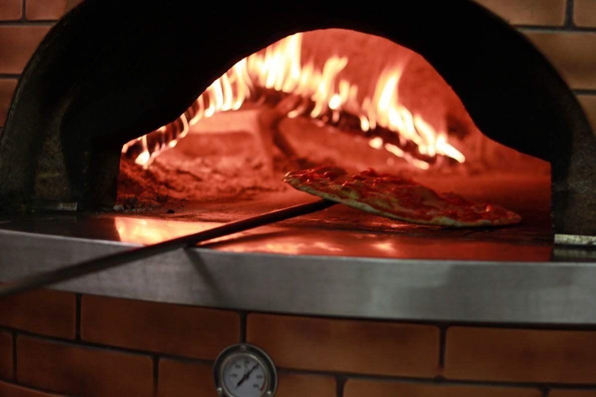 pizzaiolo inforna una pizza