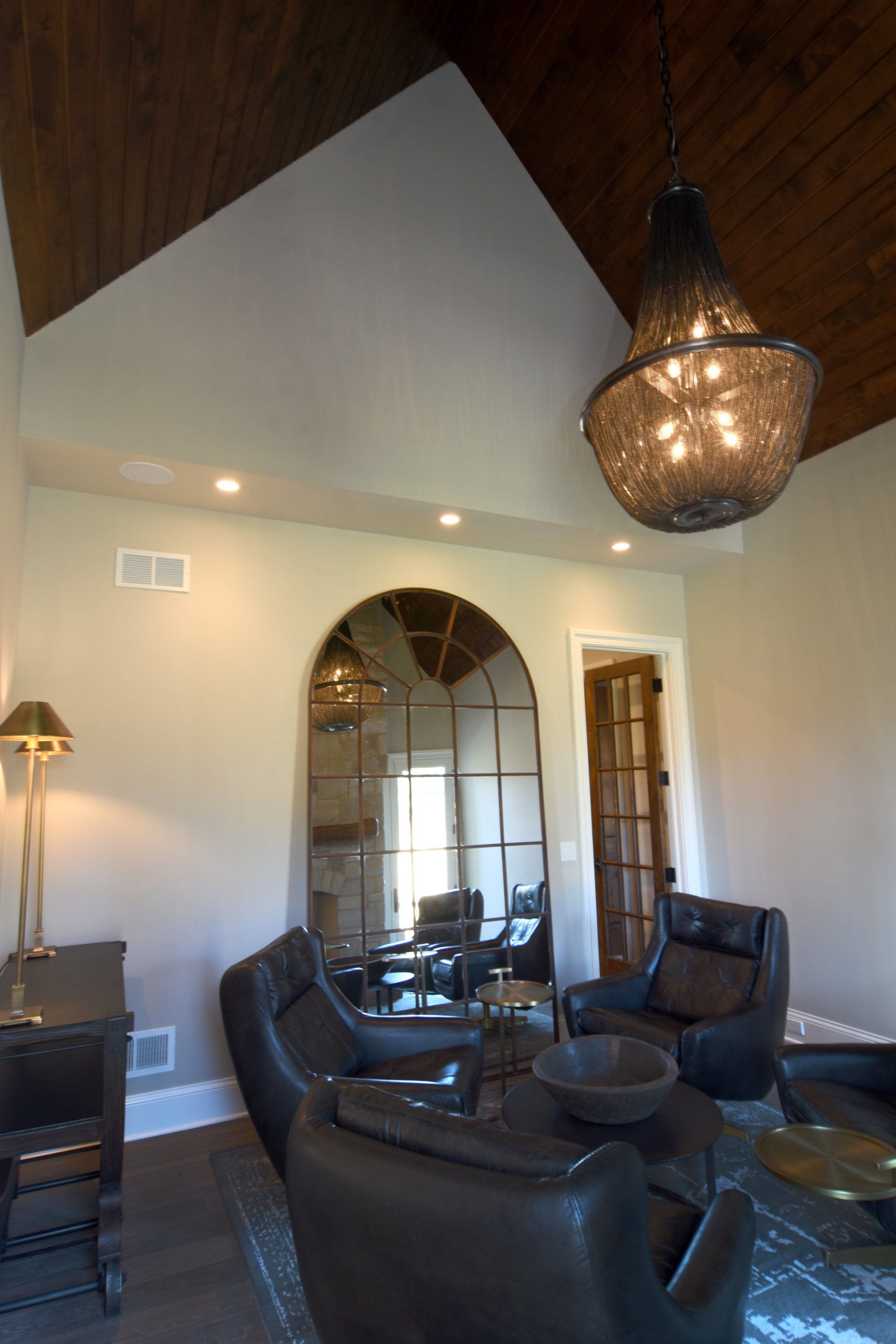 A living room with a vaulted ceiling and a chandelier hanging from the ceiling.