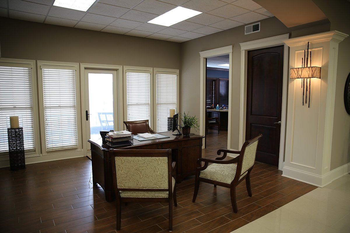 A room with a desk and chairs in it