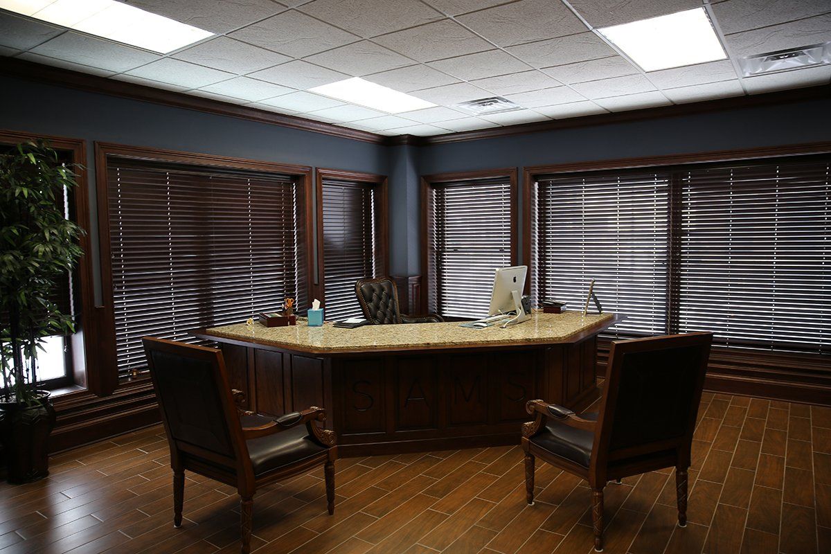 An office with a desk and chairs and a computer on it