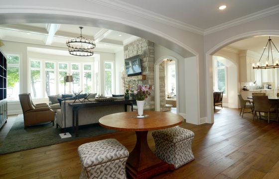 A living room with a round table and ottomans