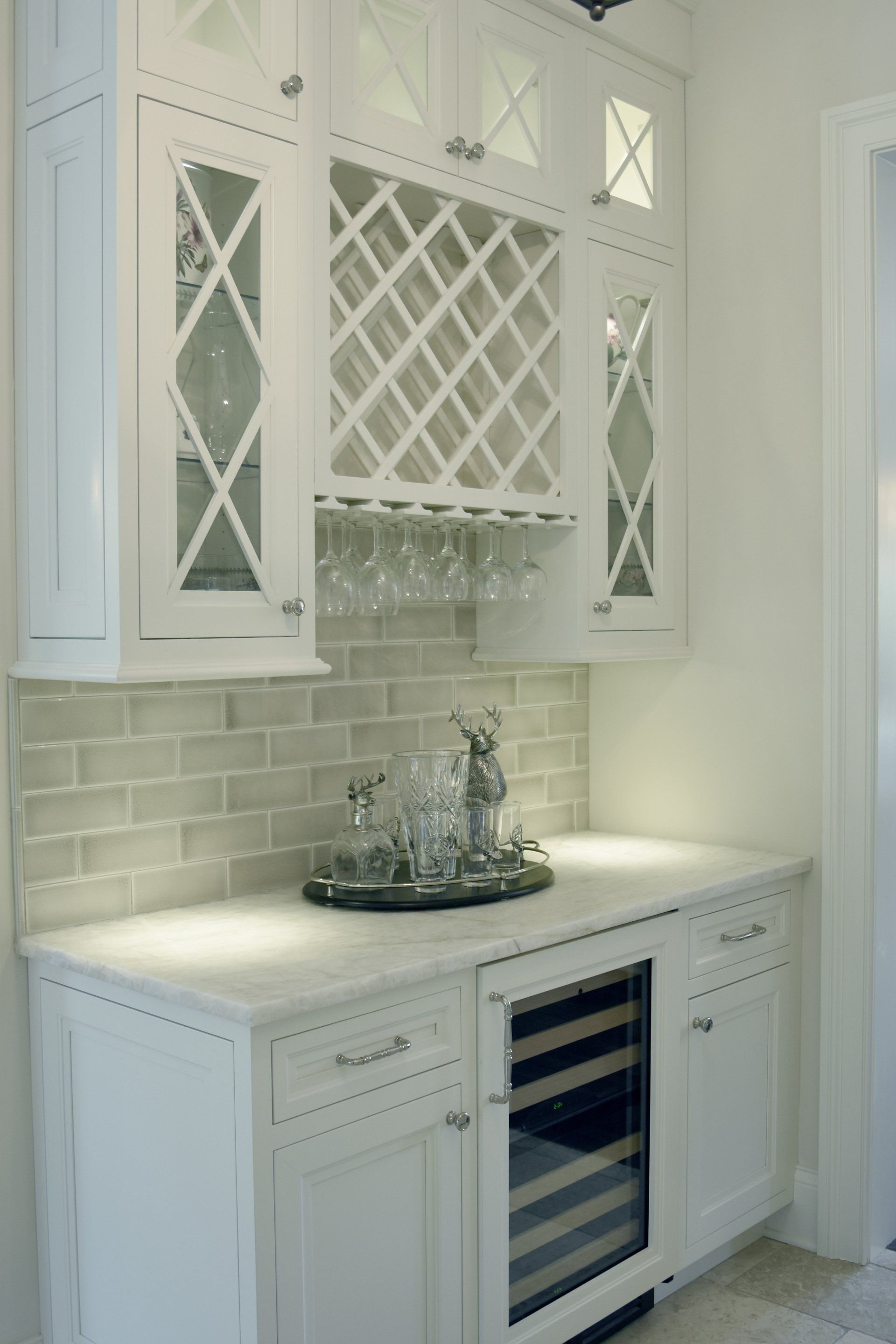 A kitchen with white cabinets and a wine cooler
