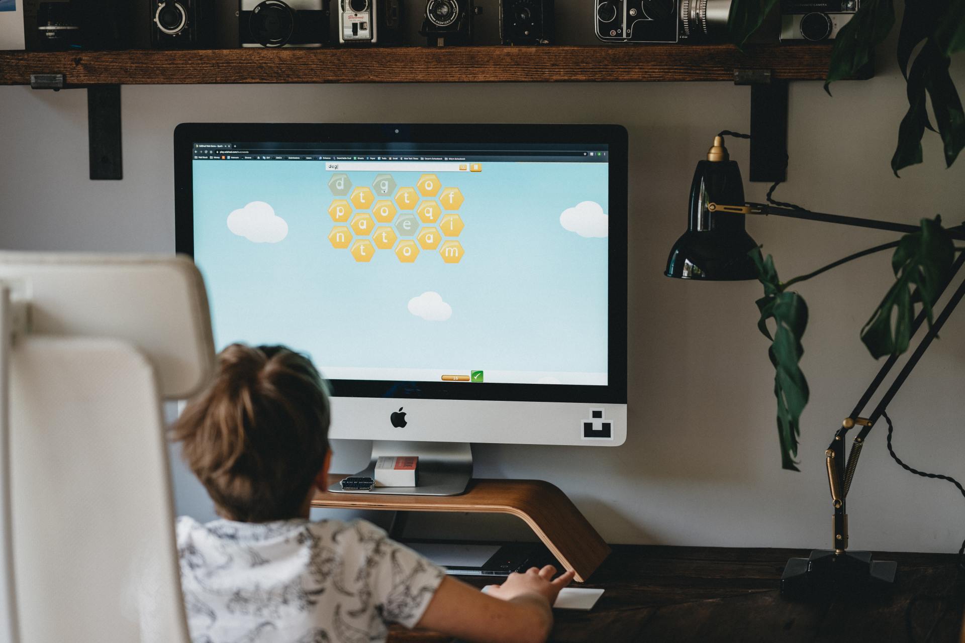 A young boy is sitting in front of an apple computer.