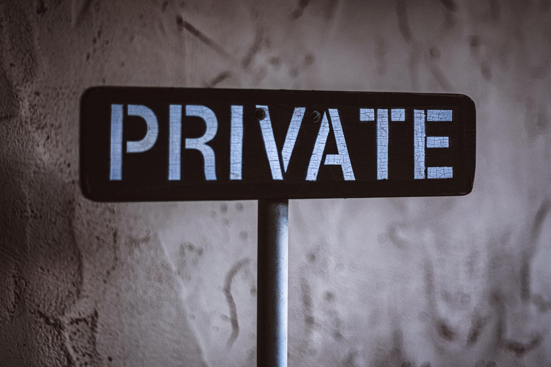A sign that says `` private '' is sitting in front of a wall.