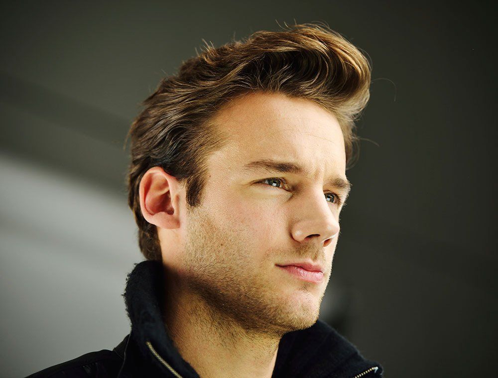 A close up of a man 's face with a black jacket on