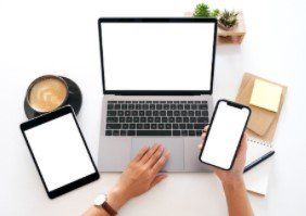 A person is using a laptop , tablet , and cell phone.