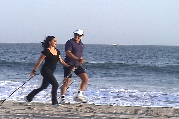 A man and a woman are walking on the beach