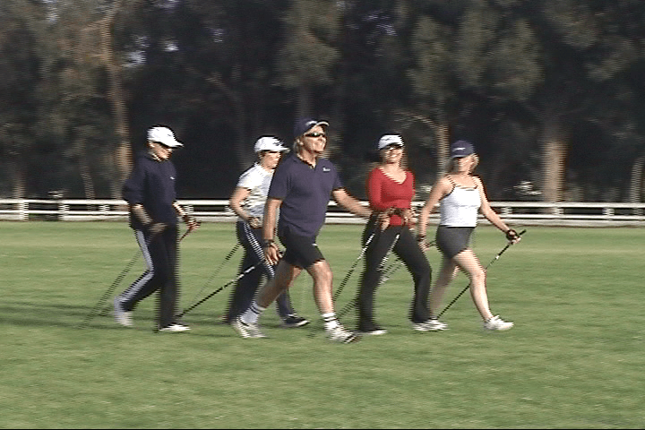 A group of people are walking on a grassy field