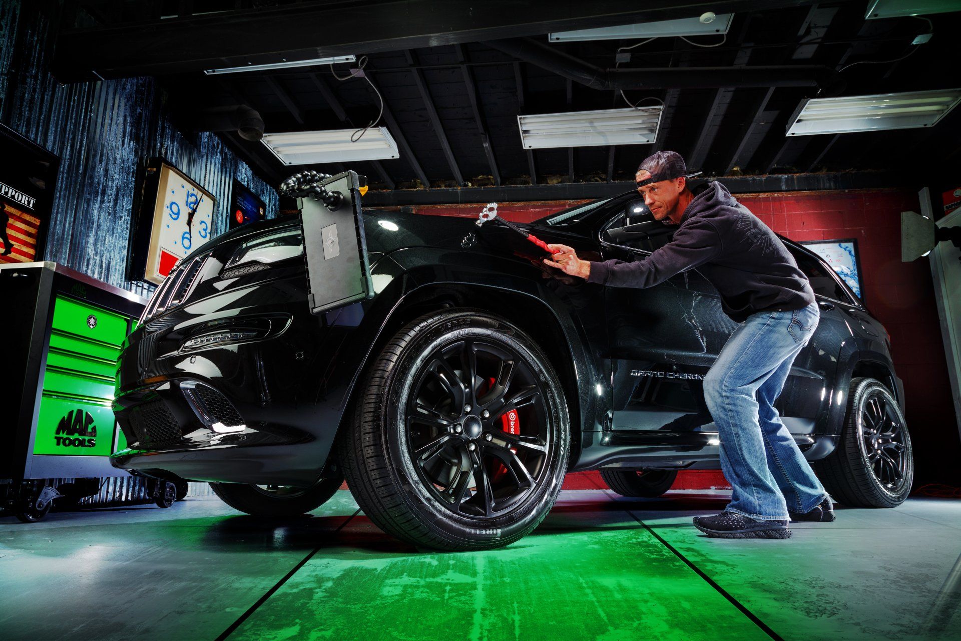 Technician performing paintless dent Repair on a Black Jeep Grand Cherokee in Mt Pleasant, Sc.