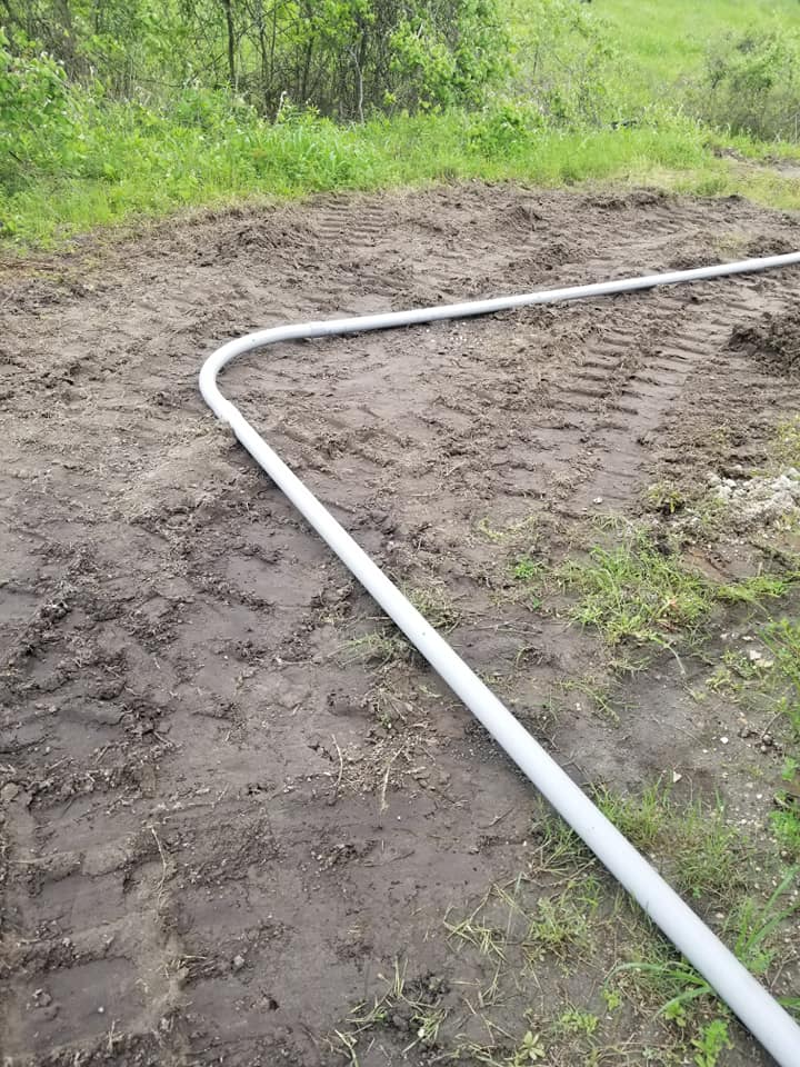 a white pipe is sitting in the middle of a dirt field .