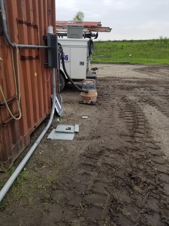 some electrical equipment are on the ground next to a building .