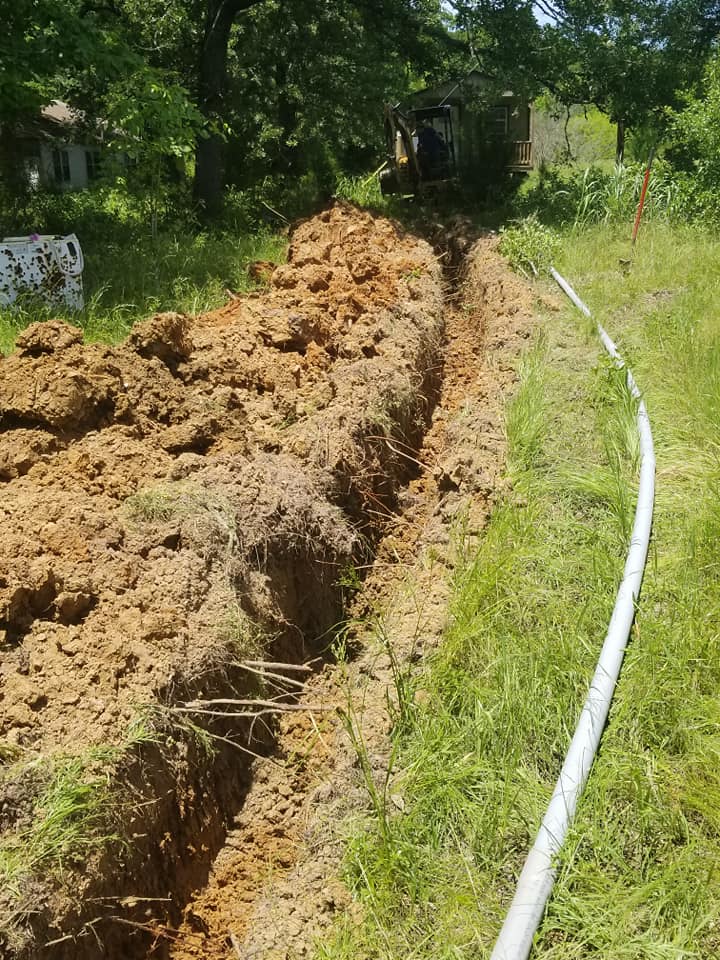 a hose is laying in the dirt next to a trench .