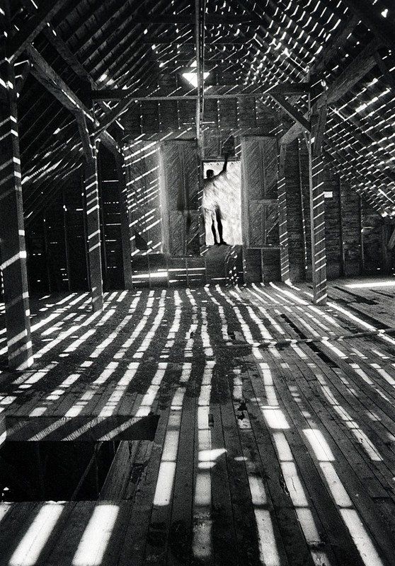 a composite image of streaks of light and shadow taken inside an empty barn-multiple exposures.