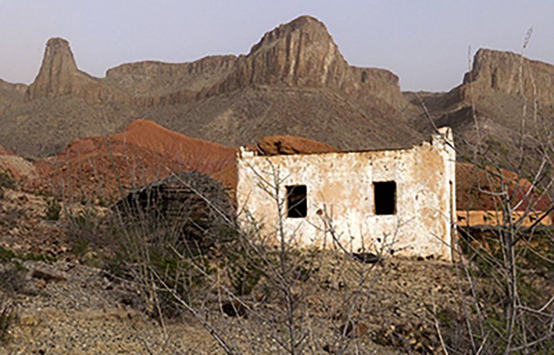 a deserted, whitewashed hacienda is contrasted by the muted colors of rugged Big Bend country.