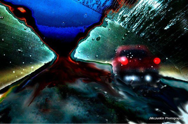 a composite image of a rainy night scene, distorted by computer manipulation