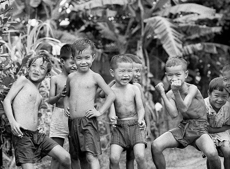 a documentary photo of Vietnamese boys hamming it up for the photographer, 1970.