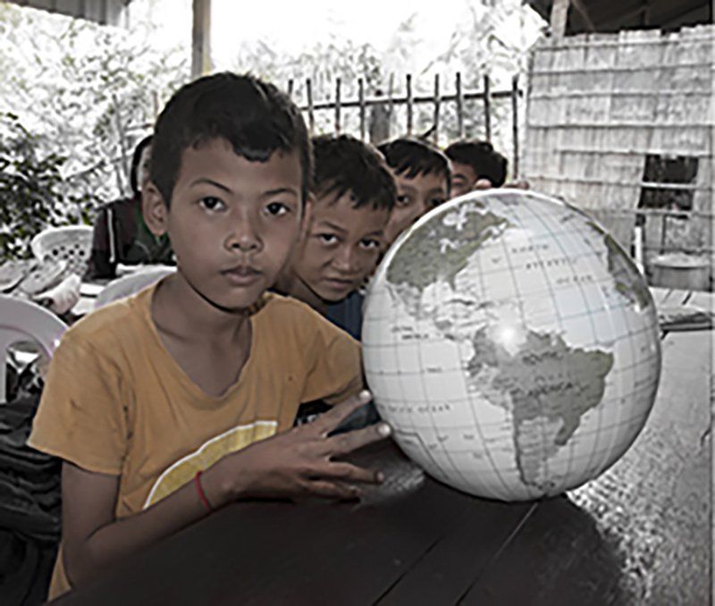 A young Vietnamese schoolboy holding a world globe