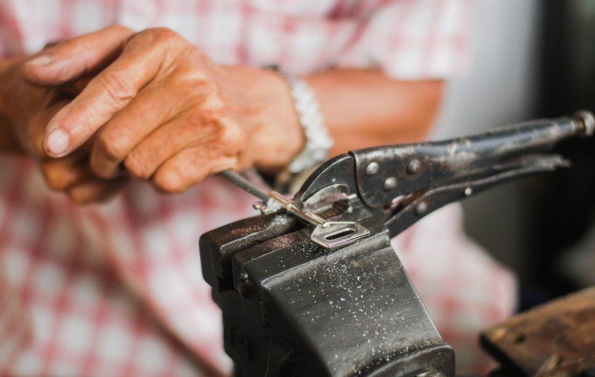 Midsection Of Locksmith Making Key.