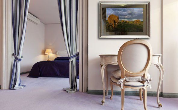 Une chambre avec un bureau, une chaise et un tableau au mur