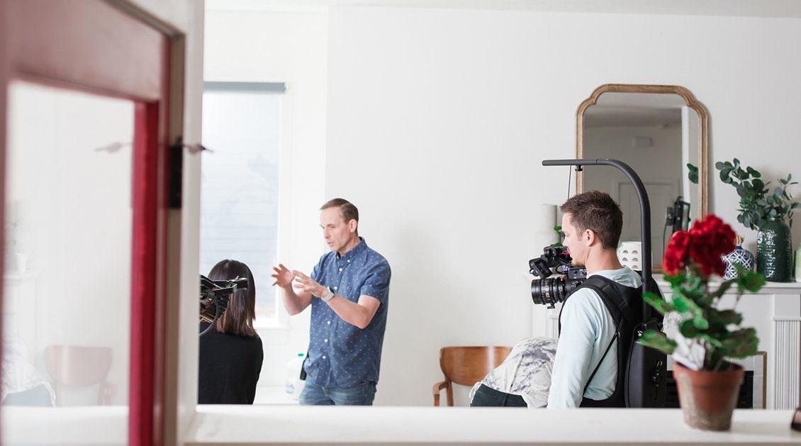 A group of people are standing in a room talking to each other.