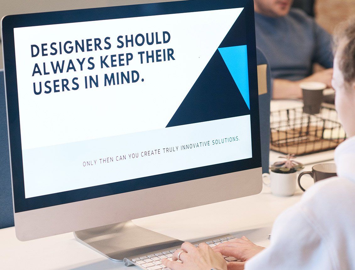 Image of a designer sitting in front of computer screen that says designers should always keep their users in mind A computer screen says designers should always keep their users in mind