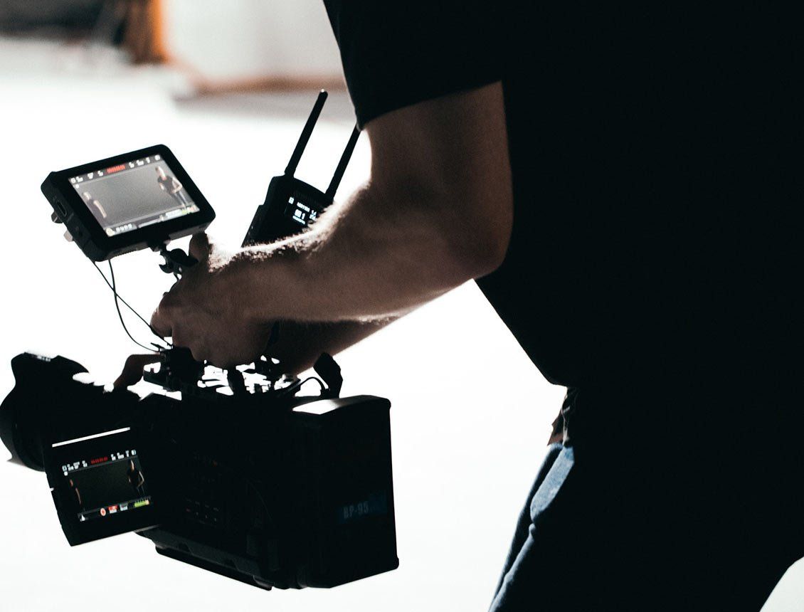 A man is holding a camera and a remote control.