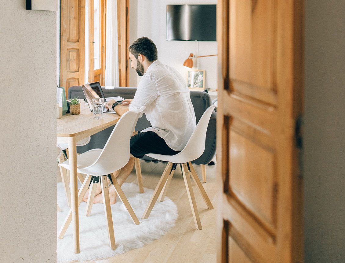 Image of man working at dining room table on laptop