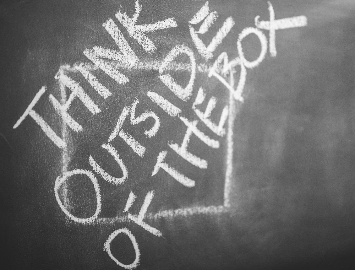 Chalk board with the worlds Think Outside the Box written on it Chalk board with the worlds Think Outside the Box written on it