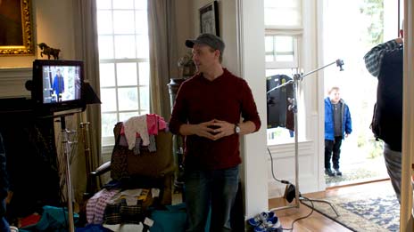 Spin Creative behind the scenes photo Treehouse brand video tv commerical shoot Matthew Billings director A man is standing in a living room in front of a television.