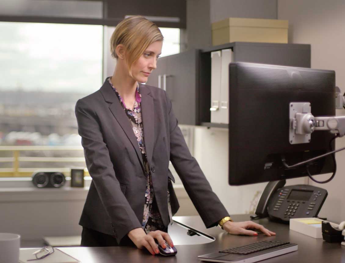 A woman in a suit is using a computer mouse