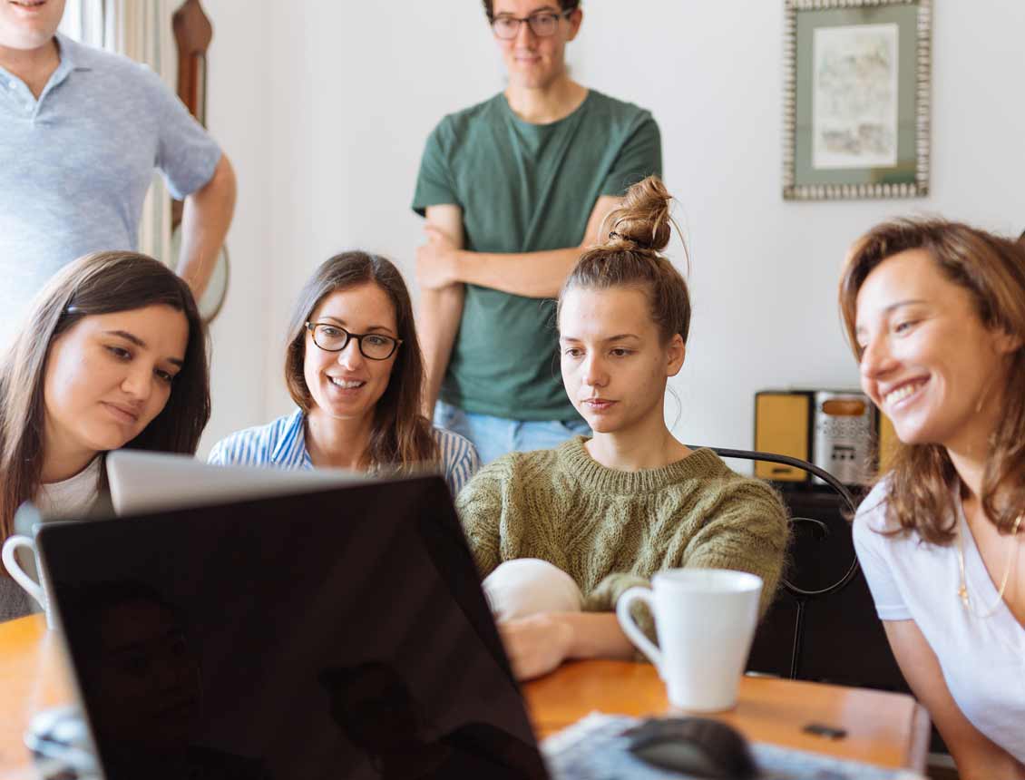 A group of people are looking at a laptop computer.