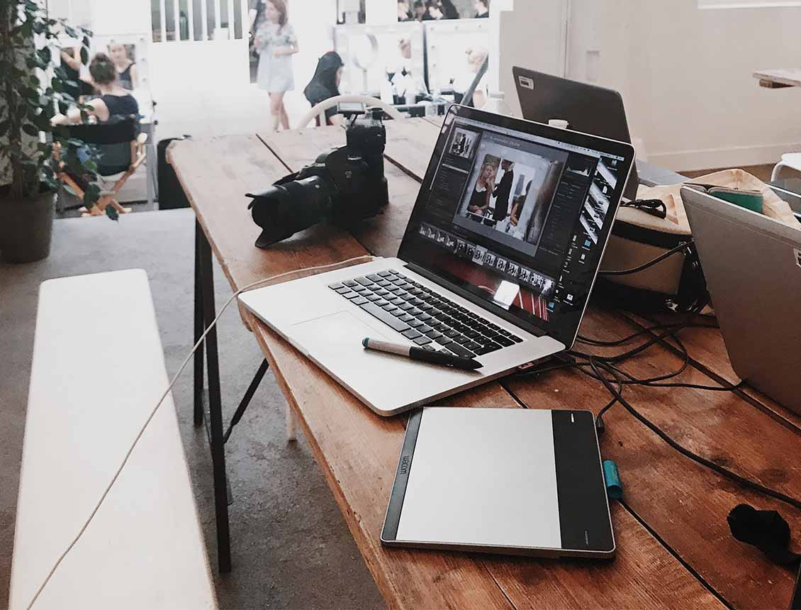 A laptop computer is sitting on top of a wooden table.